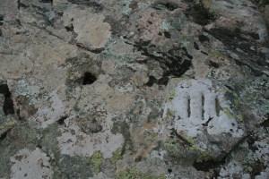 Roca amb forat i tres franges gravades al Camí Romà. Ardenya